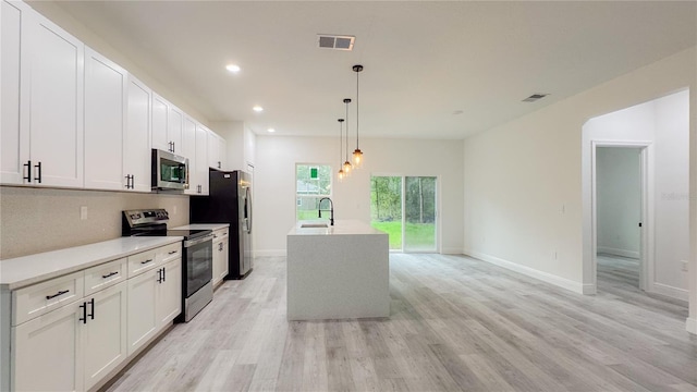 2486 W Magenta Dr, Citrus Springs, FL 34434 - kitchen featuring stainless steel appliances, light wood-style floors, recessed lighting, pendant lighting, and white cabinetry