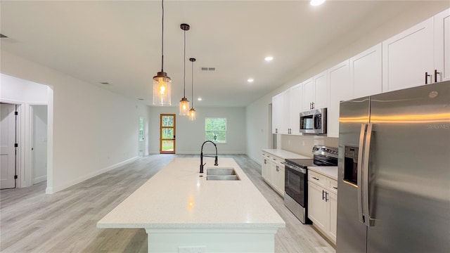 2486 W Magenta Dr, Citrus Springs, FL 34434 - kitchen with stainless steel appliances, light wood-style floors, an island with sink, white cabinetry, and recessed lighting