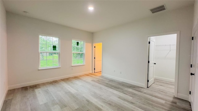 2486 W Magenta Dr, Citrus Springs, FL 34434 - unfurnished bedroom with light wood-style floors and a walk in closet