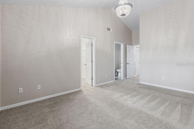 2825 NW 104th Ct Unit B, Gainesville, FL 32606 - unfurnished room with high vaulted ceiling, carpet flooring, a chandelier, and baseboards