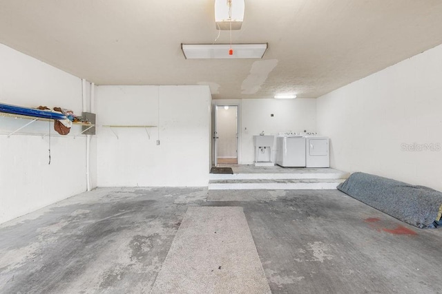2825 NW 104th Ct Unit B, Gainesville, FL 32606 - garage with washing machine and clothes dryer, a garage door opener, and a sink
