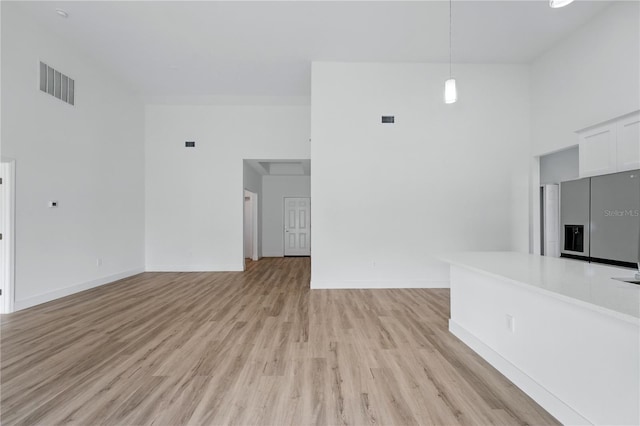 436 Caraway Dr, Kissimmee, FL 34759 - unfurnished living room with light wood-style floors and a towering ceiling