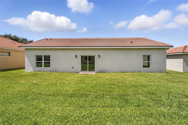 436 Caraway Dr, Kissimmee, FL 34759 - back of house featuring stucco siding, a tile roof, and a lawn