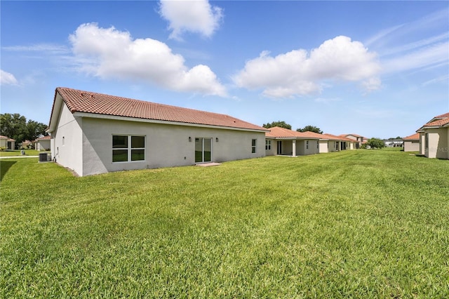 436 Caraway Dr, Kissimmee, FL 34759 - back of house with stucco siding, a tiled roof, and a yard