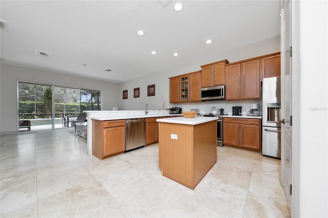 8108 Via Bella Notte, Orlando, FL 32836 - kitchen with stainless steel appliances, a peninsula, brown cabinets, light countertops, and recessed lighting