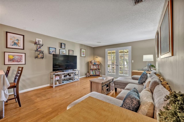 210 Magnolia Rd Unit 214, Maitland, FL 32751 - living room featuring a textured ceiling, light wood-style floors, and french doors