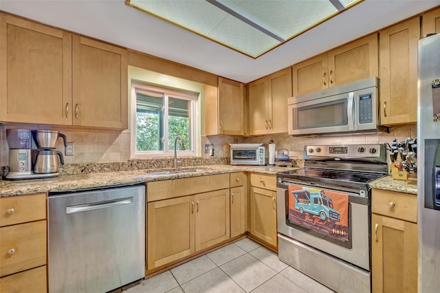 210 Magnolia Rd Unit 214, Maitland, FL 32751 - kitchen featuring appliances with stainless steel finishes, tasteful backsplash, light tile patterned flooring, and light stone countertops