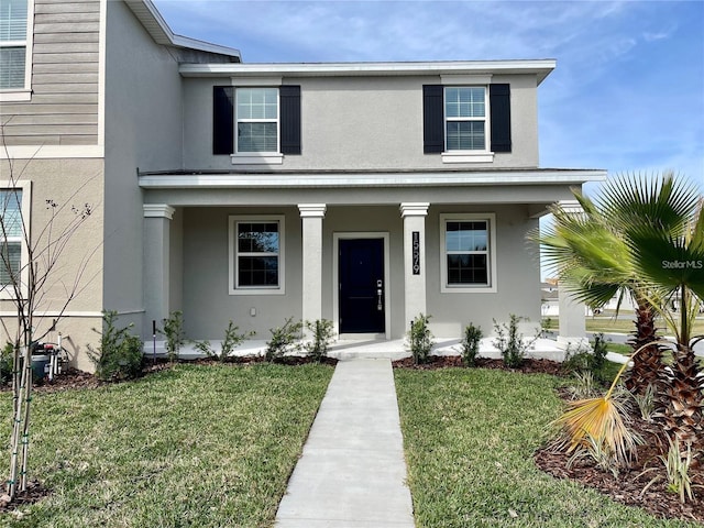 15579 Water Spring Blvd, Winter Garden, FL 34787 - view of front facade with stucco siding, a porch, and a front lawn