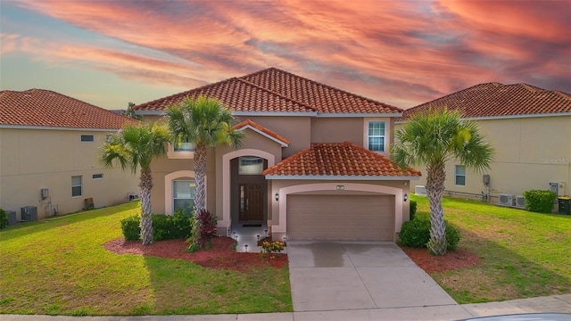 381 Cabello Dr, Davenport, FL 33837 - mediterranean / spanish-style home featuring a tile roof, a garage, stucco siding, a yard, and driveway