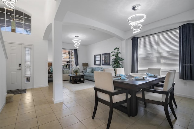 381 Cabello Dr, Davenport, FL 33837 - dining space with a chandelier, arched walkways, baseboards, and light tile patterned floors