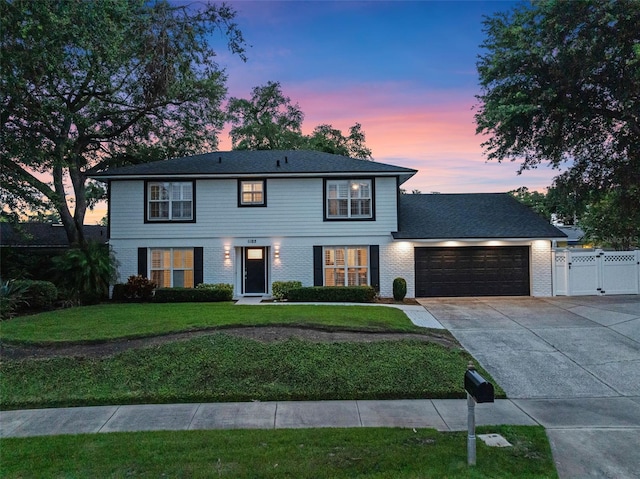 1105 Appleton Ave, Orlando, FL 32806 - colonial home with a garage, concrete driveway, a gate, and brick siding