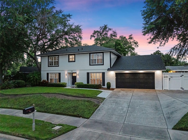 1105 Appleton Ave, Orlando, FL 32806 - colonial-style house featuring an attached garage, driveway, a gate, and brick siding