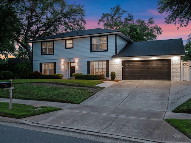 1105 Appleton Ave, Orlando, FL 32806 - colonial home featuring a garage, driveway, a yard, and brick siding
