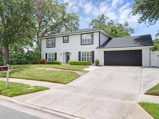 1105 Appleton Ave, Orlando, FL 32806 - colonial-style house with concrete driveway, a front lawn, an attached garage, and brick siding