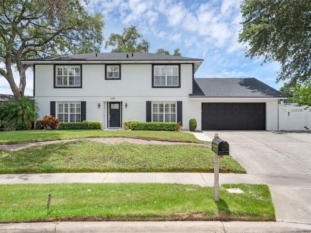 1105 Appleton Ave, Orlando, FL 32806 - view of front of house with a garage, driveway, brick siding, and a gate