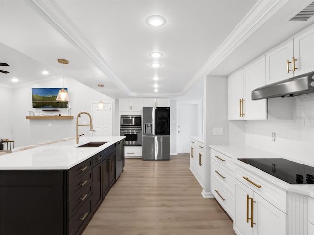 1105 Appleton Ave, Orlando, FL 32806 - kitchen with stainless steel appliances, white cabinets, under cabinet range hood, light wood-type flooring, and light countertops