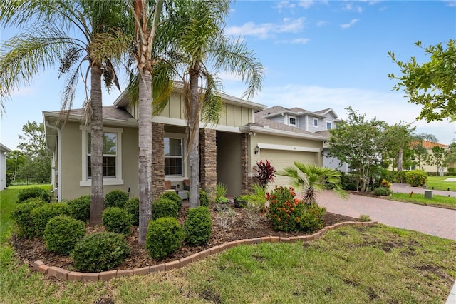 363 Miro Dr, Davenport, FL 33837 - view of front of property with stone siding, stucco siding, a garage, and decorative driveway