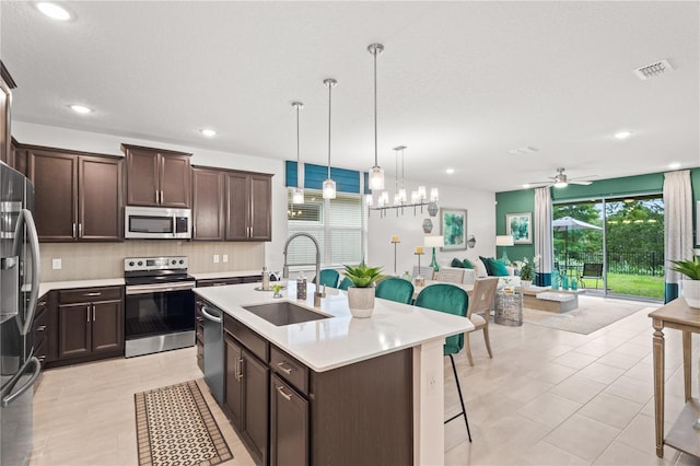 363 Miro Dr, Davenport, FL 33837 - kitchen featuring stainless steel appliances, dark brown cabinets, light countertops, tasteful backsplash, and open floor plan