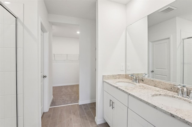 1732 Brekey Way, Zephyrhills, FL 33541 - full bathroom with a walk in closet, a stall shower, double vanity, and wood finished floors