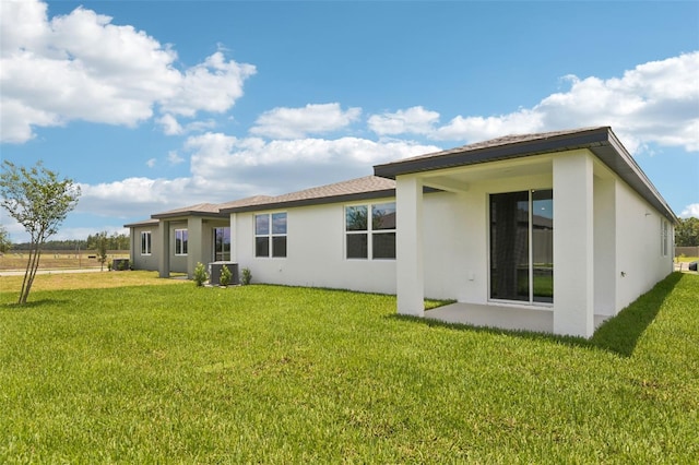 1732 Brekey Way, Zephyrhills, FL 33541 - rear view of property featuring stucco siding and a yard