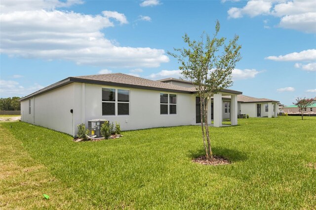 1732 Brekey Way, Zephyrhills, FL 33541 - back of property featuring a yard, stucco siding, and a shingled roof
