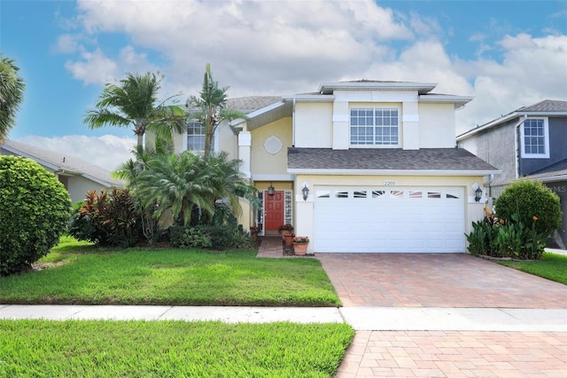 2205 Wyndam Way, Kissimmee, FL 34743 - view of front of property featuring stucco siding, decorative driveway, a garage, and a front yard