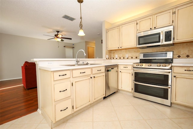 2205 Wyndam Way, Kissimmee, FL 34743 - kitchen with appliances with stainless steel finishes, cream cabinetry, a peninsula, and ceiling fan