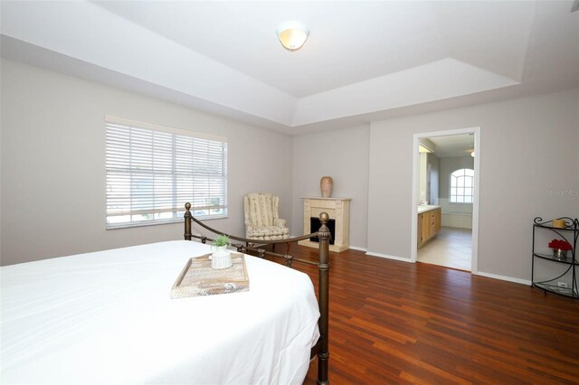 2205 Wyndam Way, Kissimmee, FL 34743 - bedroom with a raised ceiling, wood finished floors, and connected bathroom