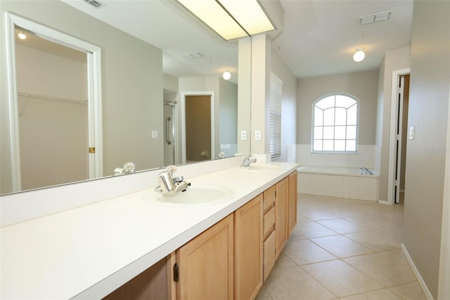 2205 Wyndam Way, Kissimmee, FL 34743 - full bathroom with double vanity, a garden tub, tile patterned flooring, a stall shower, and a spacious closet