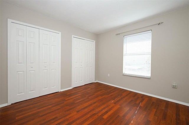2205 Wyndam Way, Kissimmee, FL 34743 - unfurnished bedroom featuring two closets and dark wood finished floors