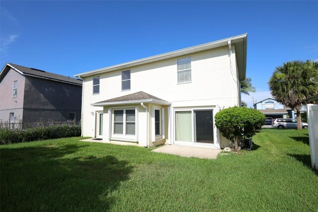 2205 Wyndam Way, Kissimmee, FL 34743 - rear view of house with stucco siding and a lawn