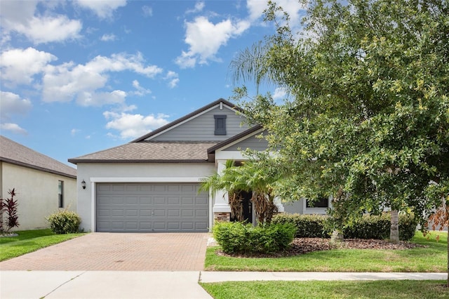 13209 Haystack Ct, Riverview, FL 33579 - view of front facade with decorative driveway, an attached garage, a shingled roof, and stucco siding