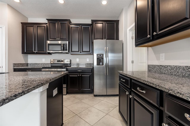 13209 Haystack Ct, Riverview, FL 33579 - kitchen with appliances with stainless steel finishes, dark stone counters, light tile patterned floors, and recessed lighting