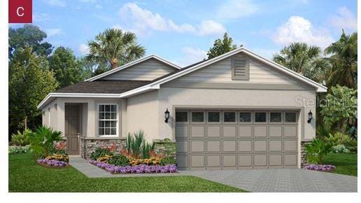 1202 Atlantic Ave, Fruitland Park, FL 34731 - view of front facade featuring a garage, stucco siding, stone siding, and driveway