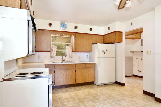 1607 Lindale Ave, Eustis, FL 32726 - kitchen featuring white appliances, light countertops, a ceiling fan, light flooring, and brown cabinetry