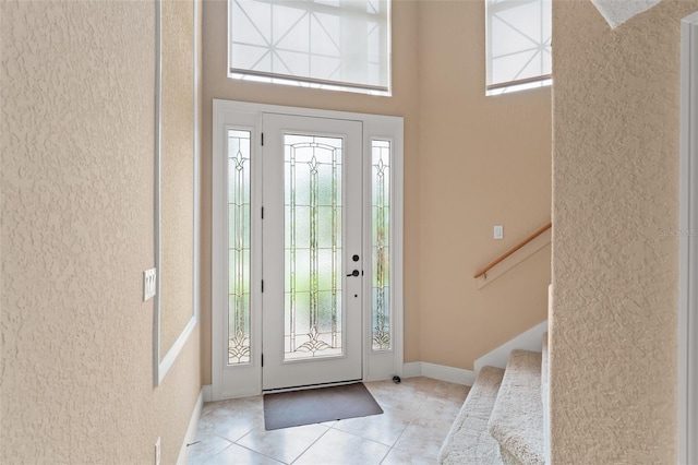 600 Egret Place Dr, Winter Garden, FL 34787 - foyer featuring tile patterned floors, stairs, a towering ceiling, and baseboards