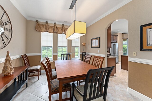 600 Egret Place Dr, Winter Garden, FL 34787 - dining space with arched walkways, light tile patterned floors, ornamental molding, and baseboards