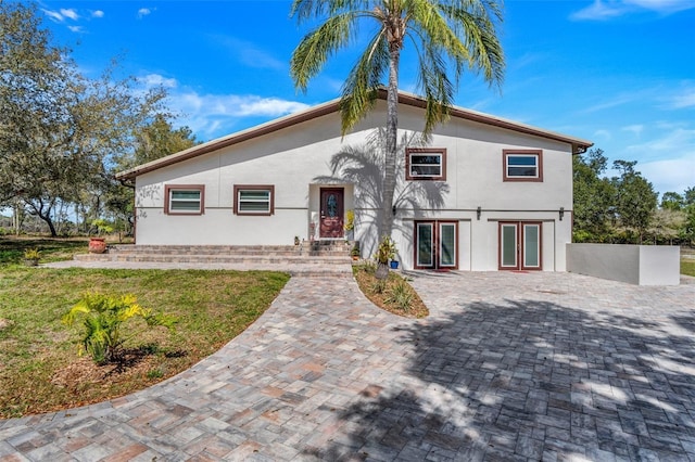 40140 Swift Rd, Eustis, FL 32736 - view of front of home featuring french doors, stucco siding, and a front lawn