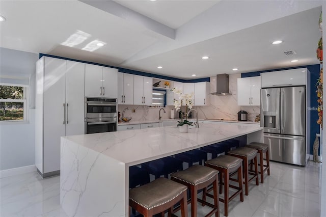 40140 Swift Rd, Eustis, FL 32736 - kitchen featuring stainless steel appliances, wall chimney range hood, tasteful backsplash, white cabinets, and light marble finish flooring