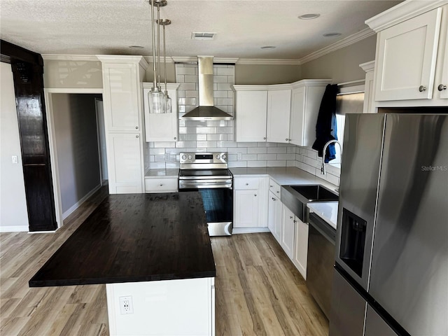 227 Bay St, Port St Joe, FL 32456 - kitchen with stainless steel appliances, wall chimney range hood, a sink, a kitchen island, and tasteful backsplash