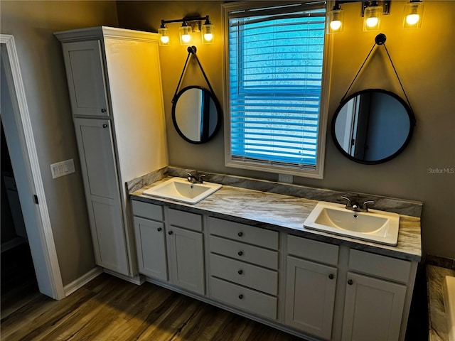 227 Bay St, Port St Joe, FL 32456 - bathroom with plenty of natural light, double vanity, wood finished floors, and baseboards