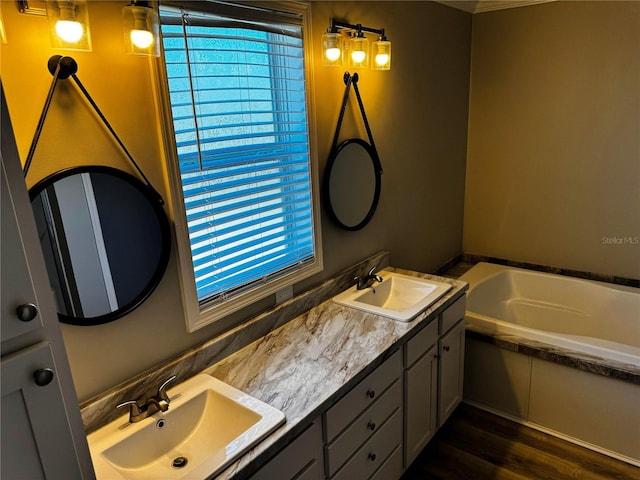227 Bay St, Port St Joe, FL 32456 - bathroom with a bath, double vanity, healthy amount of natural light, and wood finished floors