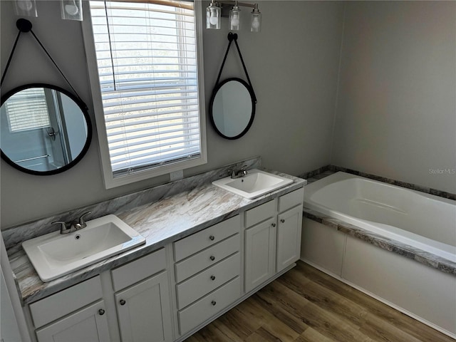 227 Bay St, Port St Joe, FL 32456 - full bath featuring double vanity, a bath, and wood finished floors