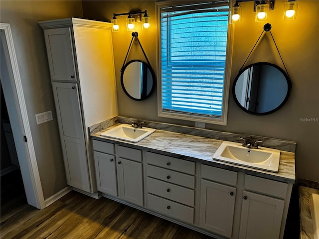 227 Bay St, Port St Joe, FL 32456 - full bathroom with double vanity, wood finished floors, and baseboards