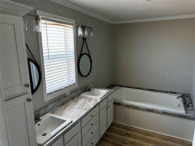 227 Bay St, Port St Joe, FL 32456 - full bathroom with a garden tub, double vanity, wood finished floors, and crown molding