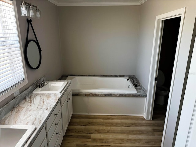 227 Bay St, Port St Joe, FL 32456 - full bath featuring double vanity, a bath, wood finished floors, toilet, and ornamental molding
