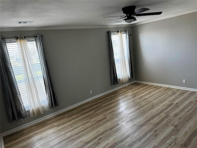 227 Bay St, Port St Joe, FL 32456 - spare room with wood finished floors, ceiling fan, crown molding, a textured ceiling, and baseboards