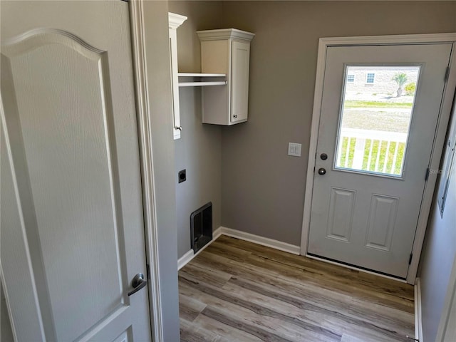 227 Bay St, Port St Joe, FL 32456 - washroom featuring light wood-style floors, electric dryer hookup, baseboards, and cabinet space