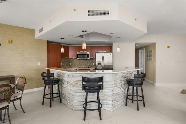 241 Riverside Dr Unit 902, Holly Hill, FL 32117 - kitchen with stainless steel appliances, a breakfast bar area, light tile patterned floors, backsplash, and recessed lighting