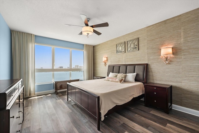 241 Riverside Dr Unit 902, Holly Hill, FL 32117 - bedroom featuring dark wood-style flooring, a ceiling fan, and a textured ceiling